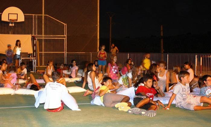 Campamento inglés, los niños se disponen a ver una película al aire libre en la pista polideportiva del albergue (Copiar)